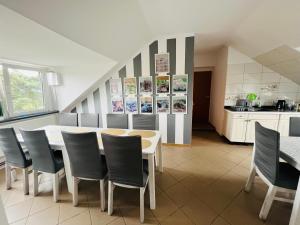 a dining room with a table and chairs and a kitchen at Borowikowa Knieja in Brody