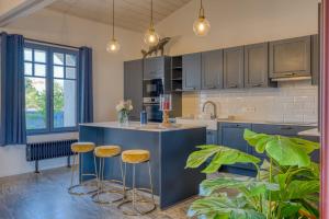 a kitchen with a blue island with stools at Villa Les Bains de Mer avec spa in Saint-Gilles-Croix-de-Vie +22 photos