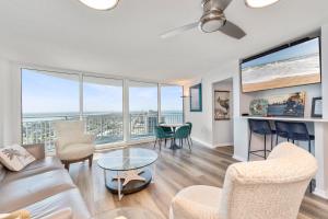 a living room with a couch and chairs and windows at On the Beach-2/Br 2/Bath, 26th floor! Spectacular views of Ocean & River in Daytona Beach Shores