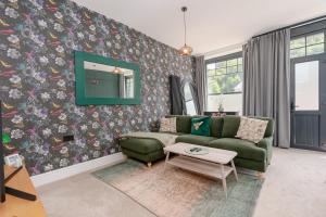 sala de estar con sofá verde y espejo en Mulberry Boutique Stay Ground Floor Canal Side, en Todmorden