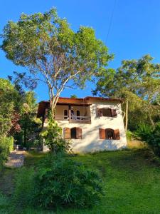 a house with a tree in front of it at Green House Chalé, hostel e pousada in Saquarema