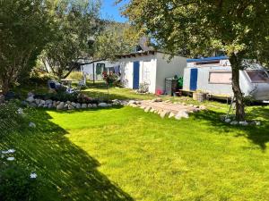 a yard with a rv parked next to a house at Dünennest Sylt - Privatgarten mit Leuchtturmblick im Herzen von Hörnum in Hörnum +44 photos