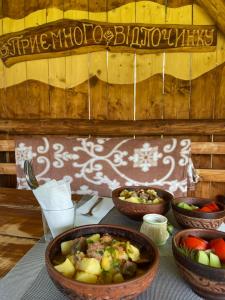 a table with three bowls of food on it at Будиночок на Лузі in Izki