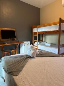 a bedroom with two bunk beds and a desk with a computer at Casa Concha-Maceio in Camocim +19 photos
