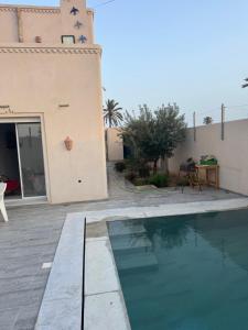 a house with a swimming pool in front of a building at Traditional home in Temlale
