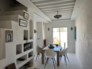 a dining room with a table and white chairs at Traditional home in Temlale