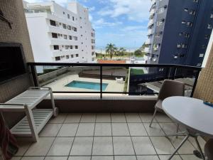 a balcony with a view of a swimming pool on a building at Caioba Apto Confortavel in Matinhos