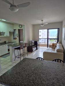 a kitchen and living room with a couch and a table at Caioba Apto Confortavel in Matinhos
