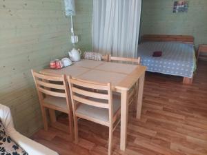 a wooden table and chairs in a room with a bed at Eedu suvila in Saaremaa