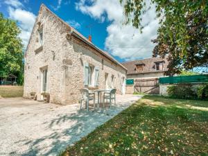 an old stone building with a table in the yard at Farmhouse in Boncourt with Private Garden in Sainte-Preuve