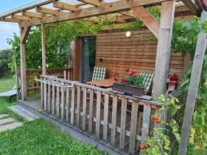 Una pérgola con una mesa y sillas en una terraza. en Pavlov24 - Domeček u potoka, en Pavlov