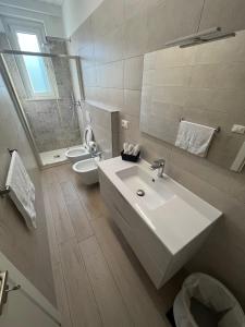 een badkamer met een wastafel, een toilet en een spiegel bij Casa DeSte in Francavilla al Mare