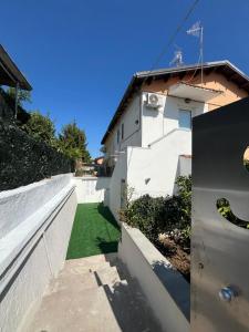 een huis met een wit hek en een groen gazon bij Casa DeSte in Francavilla al Mare