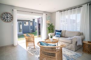 a living room with a couch and chairs and a table at Cosy Private cottages 3 bedroom salt pool DSTV in Durban