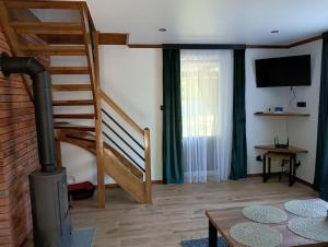 a living room with a staircase and a tv at Domek pod Dębem in Sieniawa