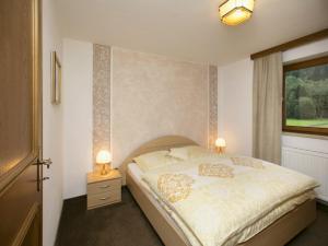 a bedroom with a bed with two lamps and a window at Apartment in Hinterbichl near Ski Bus in Reutte