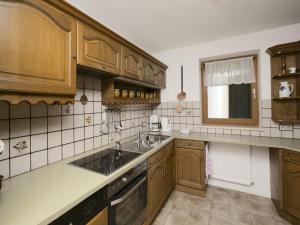 a kitchen with wooden cabinets and a sink at Apartment in Hinterbichl near Ski Bus in Reutte
