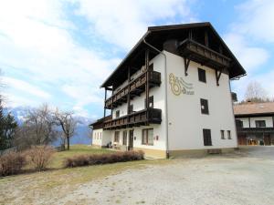 a large white building with a black roof at Apartment in St Stefan near Nassfeld Ski Area in Tratten