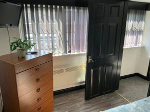 a bedroom with a black door and a dresser and a window at Rain Hill Cottage - Sleeps 4 Parking & Pets Ok in Louth +18 photos