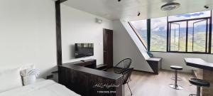 a bedroom with a bed and a desk with a tv at Highland Homestay Kundasang in Ranau