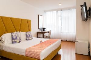 a bedroom with a large bed with a large window at Pop Art Hotel Las Colinas Manizales in Manizales