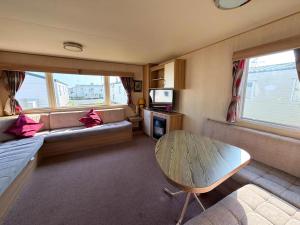 a living room with a couch and a table at Superb 8 Berth Caravan At St Osyth Beach Holiday Park, Essex Ref 28010Mv in Clacton-on-Sea