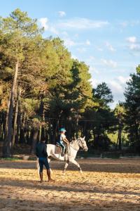 a person is riding a horse with a child on it at Hotel Apartamento Los Villares in Los Villares de Soria