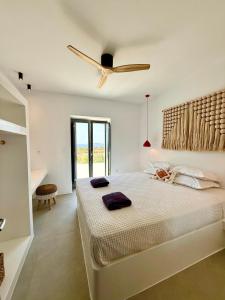 a bedroom with a bed with a ceiling fan at Faragas Hill Euphoria Villa in Angairiá +40 photos