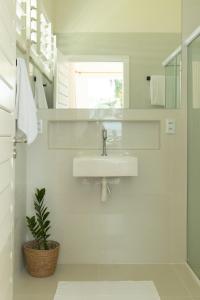イタレマにあるSoulkite House Brazilの白いバスルーム(シンク、植物付)