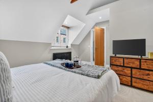 a white bedroom with a tv and a bed at 46 Tannery Mews in York