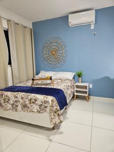 a bedroom with a bed and a blue wall at Casa aconchegante em Parnaíba in Parnaíba