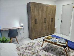 a living room with a cabinet and a coffee table at Casa aconchegante em Parnaíba in Parnaíba +24 photos
