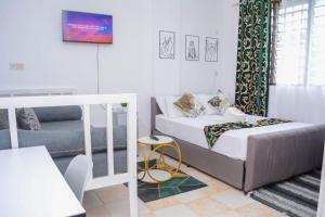a small bedroom with a bed and a couch at The Marve in Mombasa