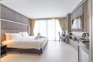 ein Hotelzimmer mit Bett und Schreibtisch in der Unterkunft Vanko International Hotel Pattaya Central in Pattaya + 48 Fotos
