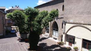 a tree sitting in front of a building at Duplex au coeur d'Embrun in Embrun