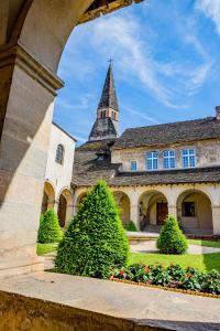 an old building with a tower and a church at La Maison de l'Apothicaire - Un refuge enchanté avec balnéo en hyper-centre in Crémieu