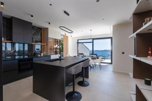 a kitchen with a large island in the middle at Villa Blue Sunset - Stunning Sea View Luxury Villa with Private Heated Pool in Brsečine +44 photos
