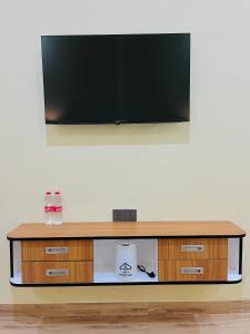 ein Flachbildfernseher auf einem hölzernen Entertainment-Center in der Unterkunft Arga Hostelry in Kareo + 16 Fotos