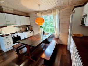 a kitchen with a table with a bench in it at Aada Villa by the slopes in Syöte