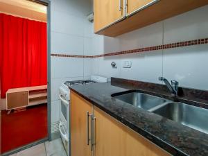 a kitchen with a sink and a red curtain at Dto dos dormitorios cerca del Español, Italiano, HPR, Club Provincial, Predio de la ex Rural in Rosario