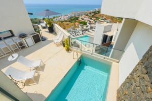 Una vista desde el balcón de una casa con piscina. en MSW34 - 5 bedroom luxury view, en Torrox Costa