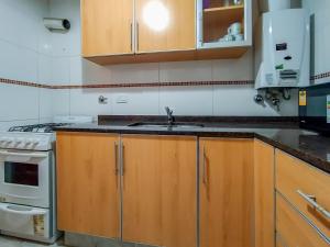 a kitchen with wooden cabinets and a sink at Dto dos dormitorios cerca del Español, Italiano, HPR, Club Provincial, Predio de la ex Rural in Rosario