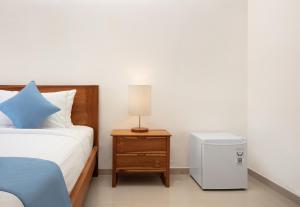 a bedroom with a bed and a night stand with a lamp at Rumah Wikan Bukit-Uluwatu in Uluwatu