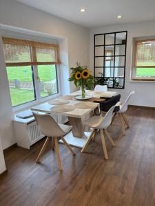 a dining room table with chairs and a vase of sunflowers at Einfamilienhaus in ruhiger Lage in Feldkirchen in Kärnten