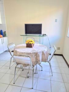 a table and chairs with a table and a television at Hospede-se bem em Salinas in Salinópolis