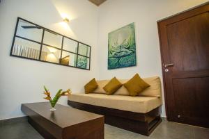 a living room with a couch and a table at Samadhi Lagoon Villa in Ratgama Hegoda
