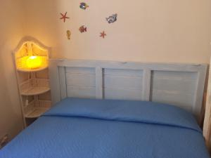 a bedroom with a bed with a blue bedspread at Cortile Via San Simone Marettimo in Marettimo
