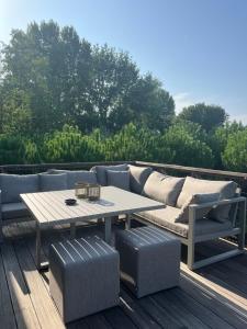 a wooden deck with a couch and a table at t'Lusthof in Ardooie