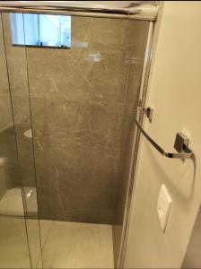 a shower with a glass door in a bathroom at Kitnet in Belém