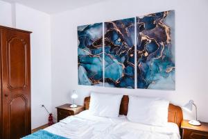 a bedroom with a bed and a painting on the wall at Renovated 1 Bedroom - Full Kitchen - Parking - 4km Tsarevets in Veliko Tŭrnovo